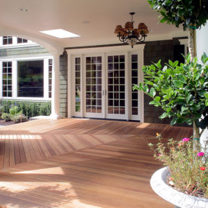 This outdoor decking area has cedar flooring. There are French doors on the patio that lead to the home’s interior. 