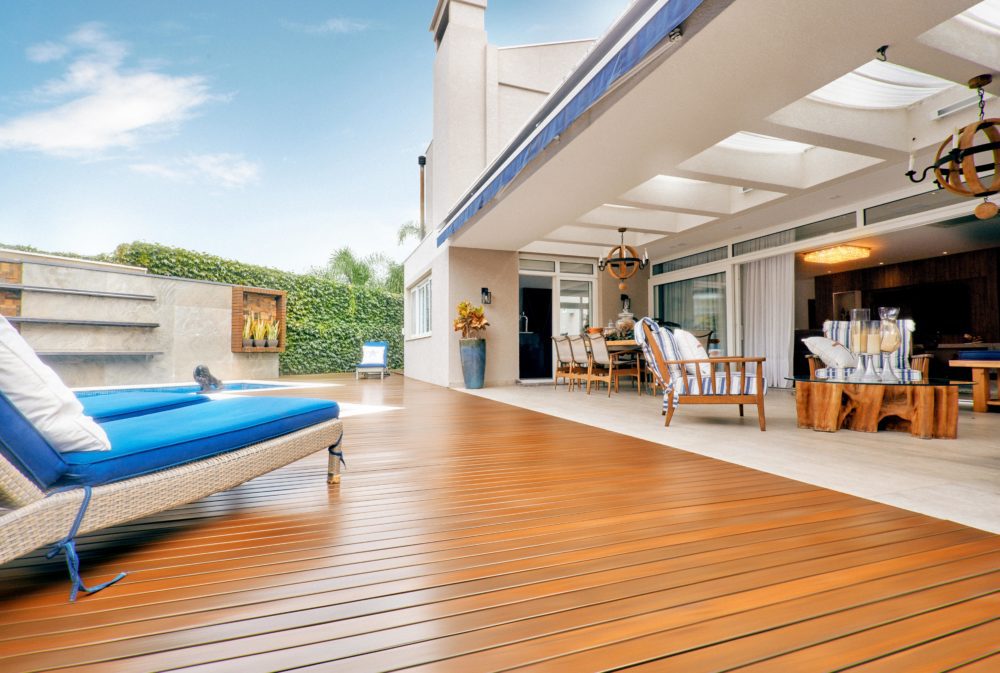 This image depicts an outdoor deck area with various seating areas and a pool.