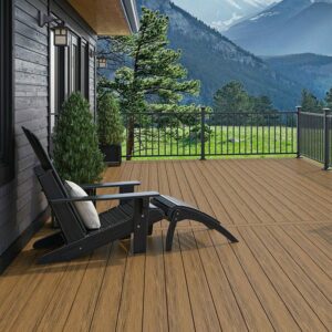 This deck with composite decking has a black Adirondack chair and two small trees. There is a black railing system on this deck.