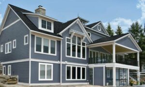 This three-story home has blue-engineered shingle siding. There is a patio area on the first and second levels of the home.