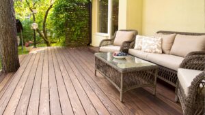 A backyard featuring Thermory composite decking and beige patio furniture.